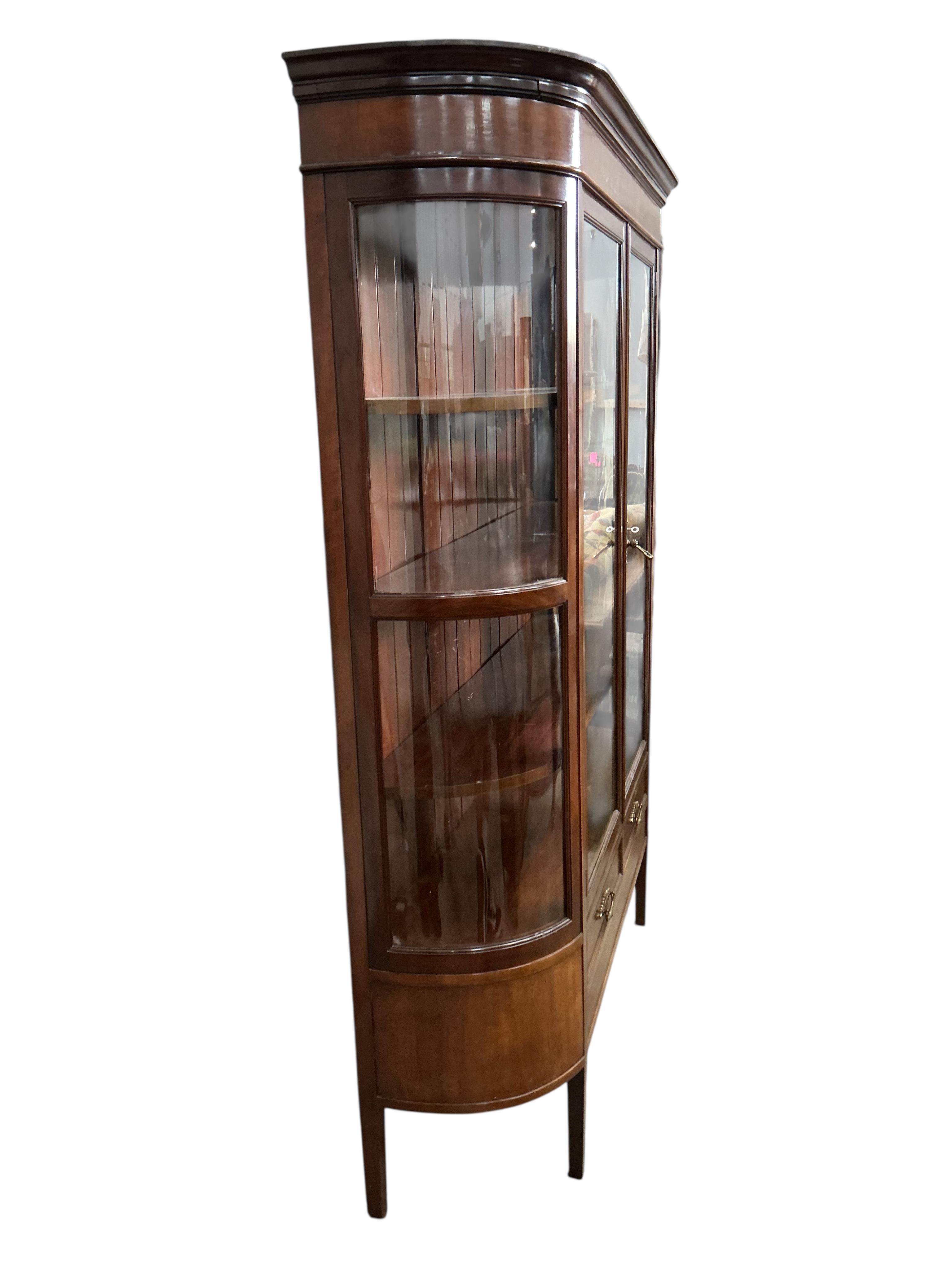 An early 20th century mahogany bookcase with two spare bow glazed door sections, width 145cm, depth 44cm, height 187cm